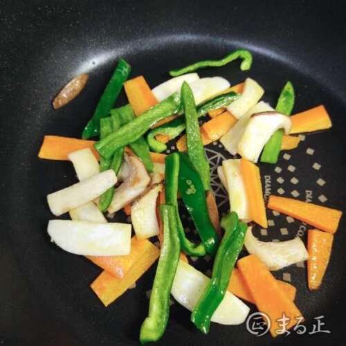 写真：野菜を順番に炒めます