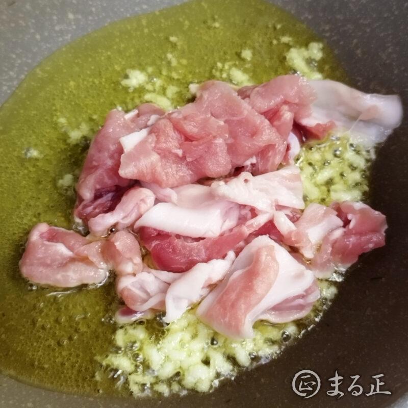にんにくと豚肉を炒める