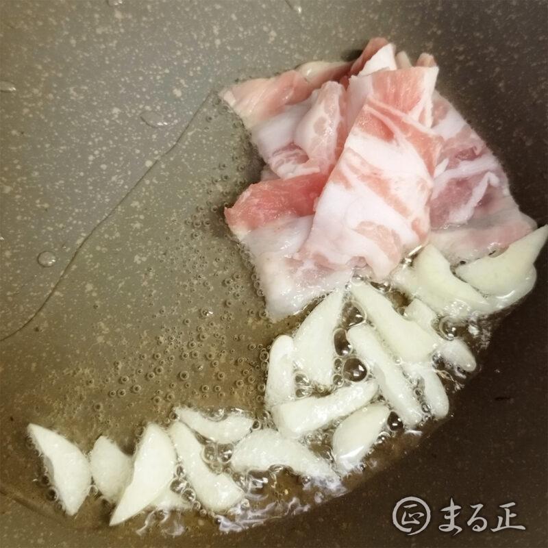 にんにくと豚肉を炒める